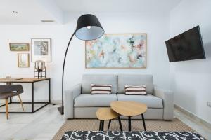 a living room with a couch and a table at Magno Apartments Redes Terrace in Seville
