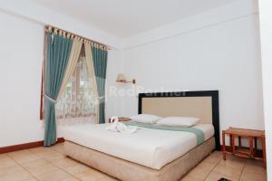 a bedroom with a bed and a window at Villa Green Valley Puncak RedPartner in Campaka