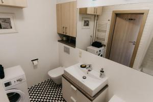 a bathroom with a sink and a washing machine at Flathouse Apartment Centrum in Białystok