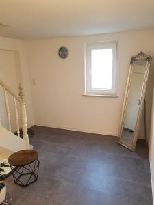 an empty room with a mirror and a staircase at Ferienwohnung an der Schelde in Dillenburg