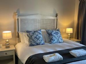 a bedroom with a bed with two tables and two lamps at Oubaai Golf Estate in George
