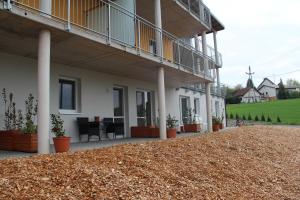 a building with a patio with a table and chairs at Aparthotel Kreuzwirt in Engerwitzdorf