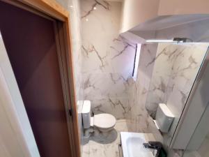 a white bathroom with a toilet and a sink at Studio lumineux à 10 min de la plage in Nice