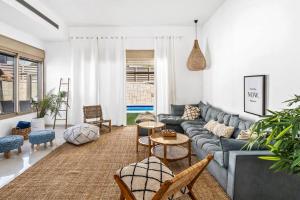 ein Wohnzimmer mit einem Sofa, Tischen und Stühlen in der Unterkunft Perfect Villa in Be’er Scheva