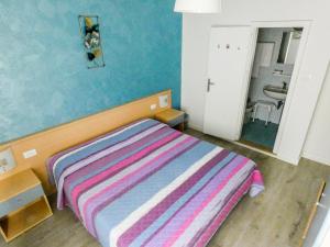 a bedroom with a bed with a striped blanket at Hotel Alpino in Malcesine