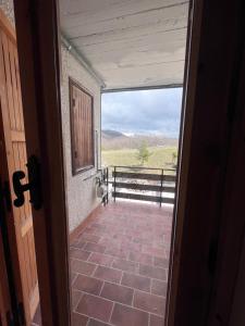 una puerta abierta a un porche con vistas a un campo en 5 confini Terminillo, en Terminillo