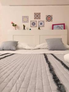 een slaapkamer met een groot wit bed en een grijze deken bij La Capinera House in Catania
