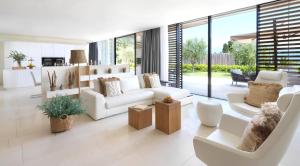 a living room with white furniture and large windows at Eden Reserve Hotel in Gardone Riviera