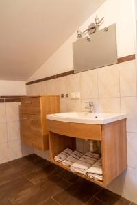 a bathroom with a sink and a mirror and towels at Appartement Höllwarthof in Goldegg