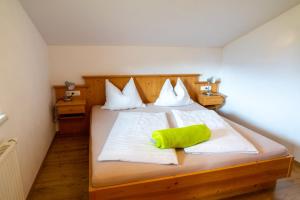 a bedroom with a bed with a green pillow on it at Appartement Höllwarthof in Goldegg