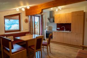 una cucina con un tavolo di legno e una sala da pranzo di Appartement Höllwarthof a Goldegg