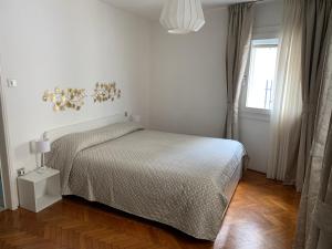 a white bedroom with a bed and a window at ROOFTOP TERRACE Domus dei fabbri in Venice