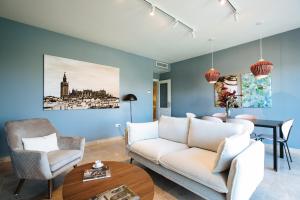 ein Wohnzimmer mit einem Sofa und einem Tisch in der Unterkunft Magno Apartments Paseo de la O - Private Parking included in Sevilla