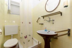 a bathroom with a sink and a toilet and a mirror at Apartment Anka in Orebić