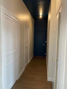un pasillo vacío con una puerta azul y una habitación en le luxe à 2 pas de la grande plage en Les Sables-dʼOlonne