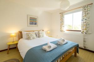 a bedroom with a bed with towels on it at Sea Poppies in Thorpeness