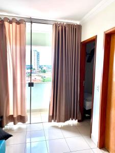 a room with a large window with a view of the city at Flats Sierra Bela Vista in Goiânia