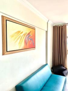 um sofá azul num quarto com uma pintura na parede em Flats Sierra Bela Vista em Goiânia