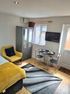 a bedroom with a bed and a table and chairs at Lovely central studio/2bed - 5min to train station in Slough