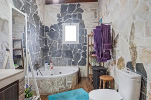 baño de piedra con bañera y aseo en Casa Juan Alba, en Vejer de la Frontera 18 fotos más