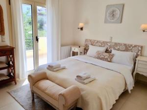 a bedroom with a large bed with towels on it at Sea Breeze - Home with a View in Bouzéïka