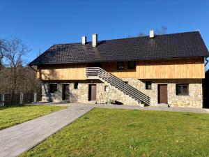a large stone building with a black roof at Mulina River Lodge in Pribanjci