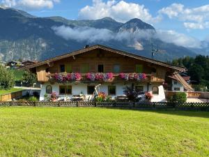 a house in a field with mountains in the background at Haus Panorama in Reith im Alpbachtal