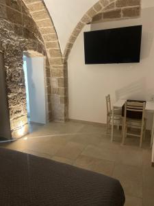 a bedroom with a table and a tv on the wall at Primo Dimora Storica in Bitonto