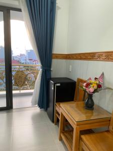 een kamer met een tafel en een vaas met bloemen erop bij HA ANH PHAN THIẾT HOTEL in Phan Thiet