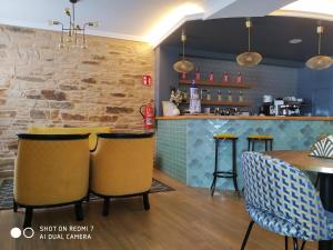 a restaurant with a bar with yellow and blue at PR Tambre in Santiago de Compostela