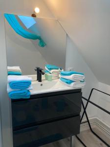 een badkamer met een wastafel met blauwe handdoeken bij Angelina in Chabris