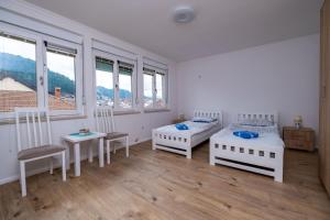 1 dormitorio con 2 camas, mesa y sillas en Central Apartment Konjic, en Konjic