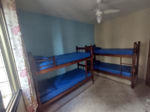 two bunk beds in a room with a ceiling fan at Apartamento vista pro Mar in Praia Grande