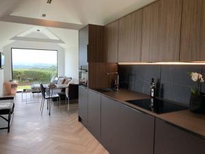 a kitchen with a counter and a table with chairs at The Cabin at Barnstormers, luxury woodland setting in Marldon