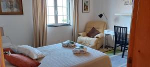a bedroom with a bed and a chair and a desk at Vivenda Faria in Vila Nova de Milfontes
