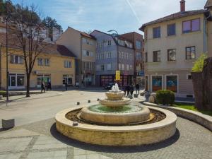 a fountain in the middle of a street with buildings at Central Apartment Konjic in Konjic