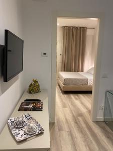 ein Schlafzimmer mit einem Bett und einem Tisch mit einem TV in der Unterkunft Suite della Scala in Verona
