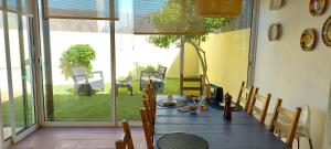 a dining room with a table and chairs and a window at Vivenda Faria in Vila Nova de Milfontes