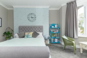 1 dormitorio con 1 cama y reloj en la pared en Seaview B&B en Harwich