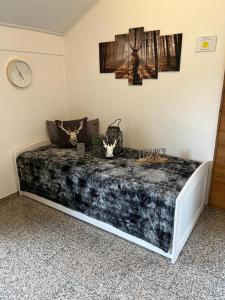 a large bed in a room with a clock on the wall at Ferienwohnung Rosl in Waldkirchen