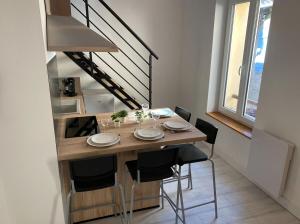 a dining room table with chairs and a staircase at L'ETERNEL in Longeville-lès-Metz