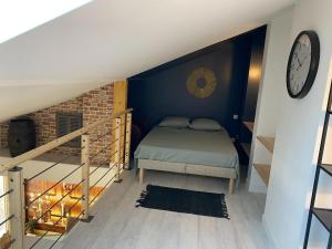 a bedroom with a bed and a clock on the wall at L'ETERNEL in Longeville-lès-Metz