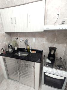 a small kitchen with a sink and a stove at Apartamento vista pro Mar in Praia Grande