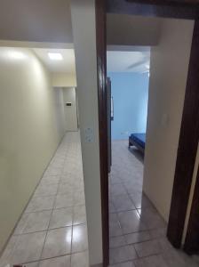 an empty room with a hallway with a couch in it at Apartamento vista pro Mar in Praia Grande