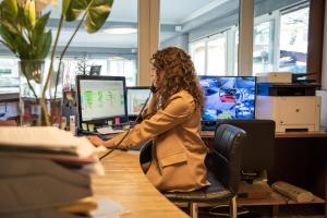 a woman sitting at a desk with a computer at Hotel Lumin in Cremia