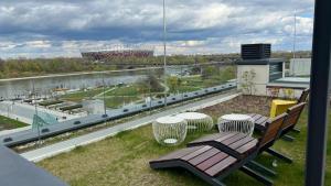 a balcony with a bench and a view of a stadium at Apartament Powiśle Deluxe in Warsaw