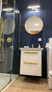 y baño con ducha, lavabo y espejo. en Apartament Powiśle Deluxe, en Varsovia