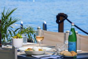 a table with a bottle of wine and a plate of food at Royal Antibes - Luxury Hotel, Résidence, Beach & Spa in Antibes