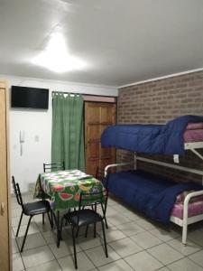 a room with a table and two bunk beds at Alojamiento Lavalle in Guaymallen