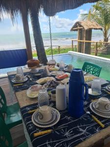 a table with food on it next to a pool at Club Manguaba Beira Mar in Japaratinga